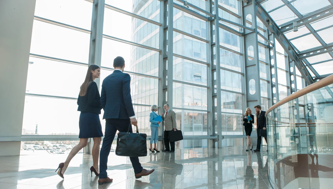 Two business people walking through light lobby